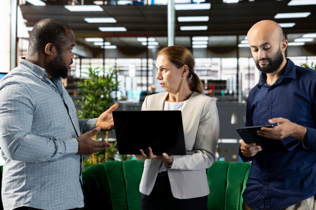 multiracial workers using laptop device to write emails, solving tasks