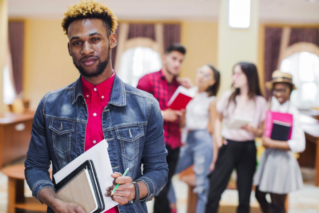 young black man posing with books